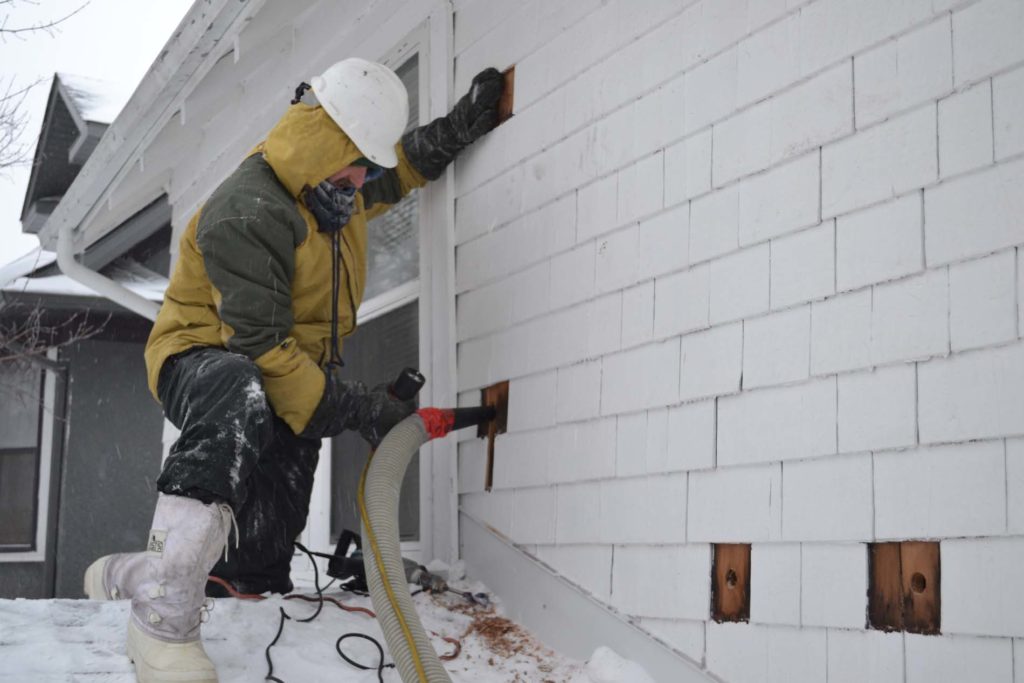 Injecting cellulose into the wall while plugging a different hole in the same cavity