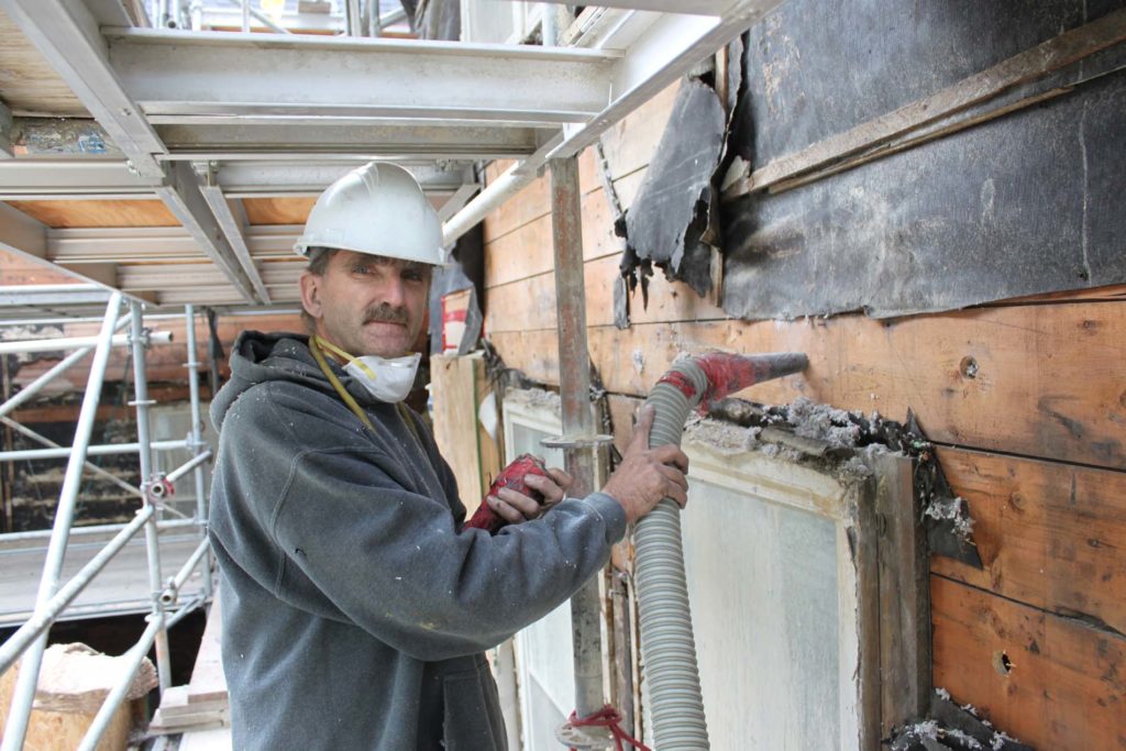 Dense-packing cellulose into the empty walls of a Wolseley house built in 1883
